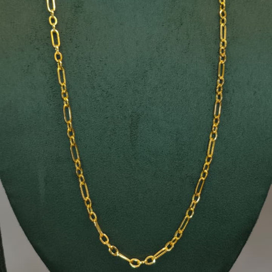 A gold chain necklace displayed on a dark green velvet jewelry bust against a light gray background.