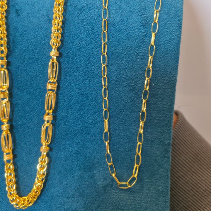 Two gold chains displayed on a blue velvet jewelry bust against a plain light background.