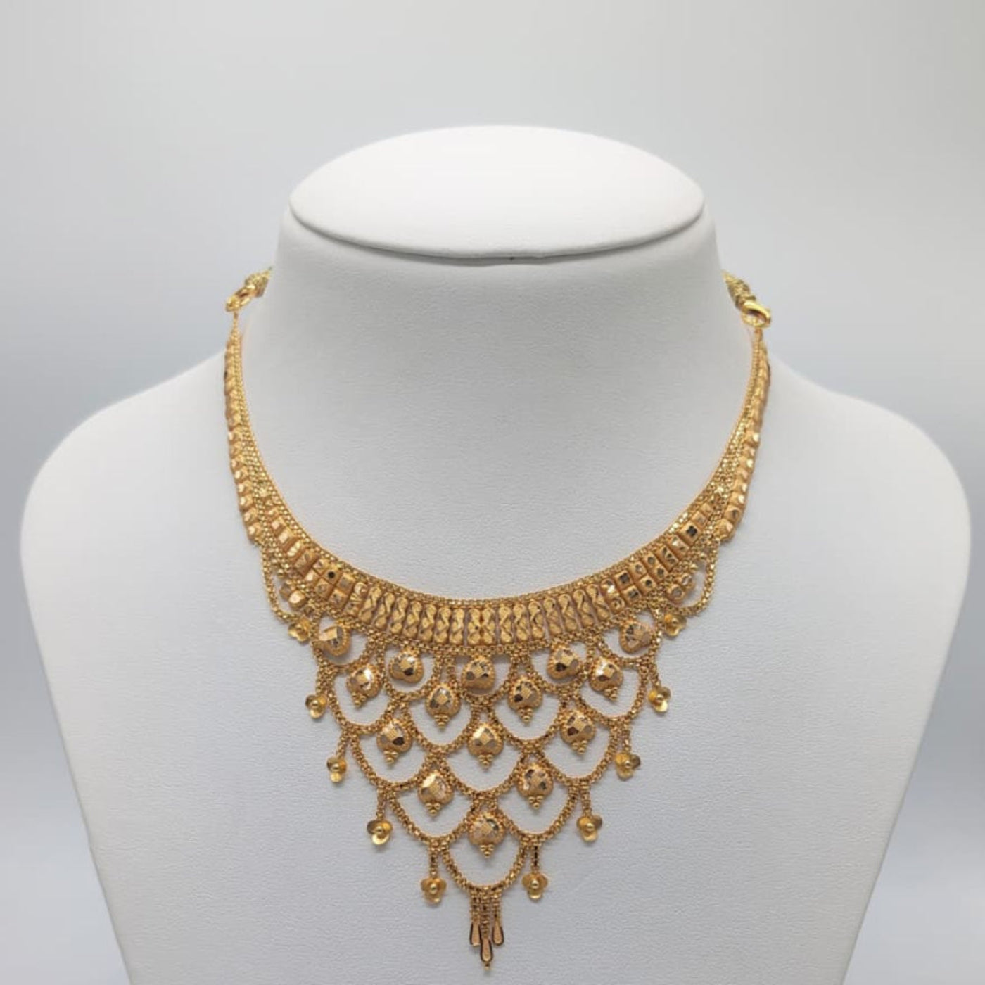 Gold necklace on a mannequin bust with weight information.