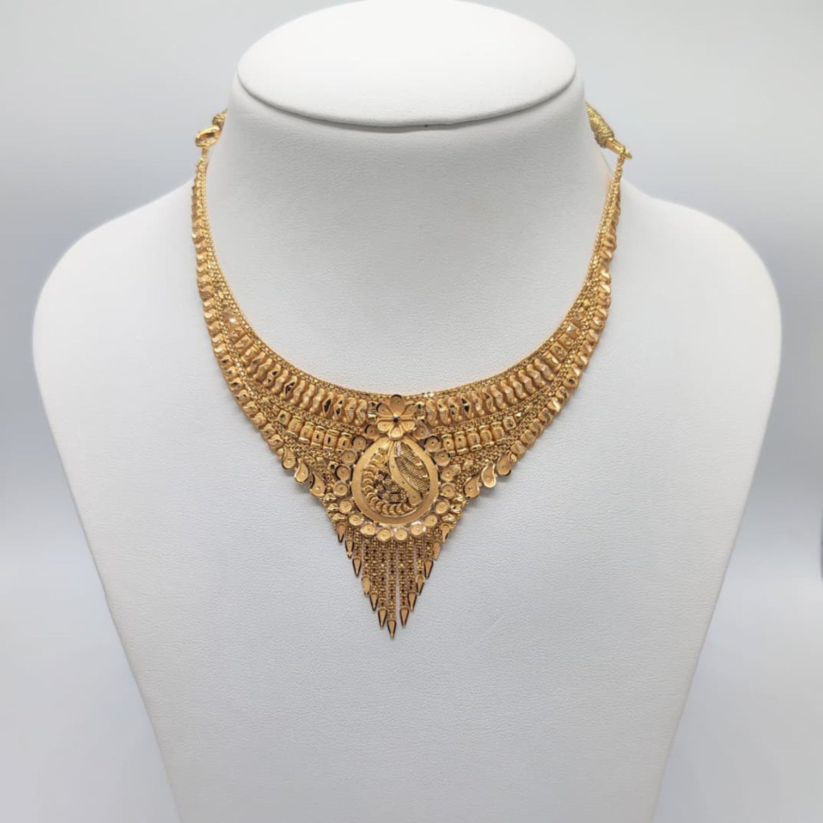 Gold necklace on a mannequin bust 
