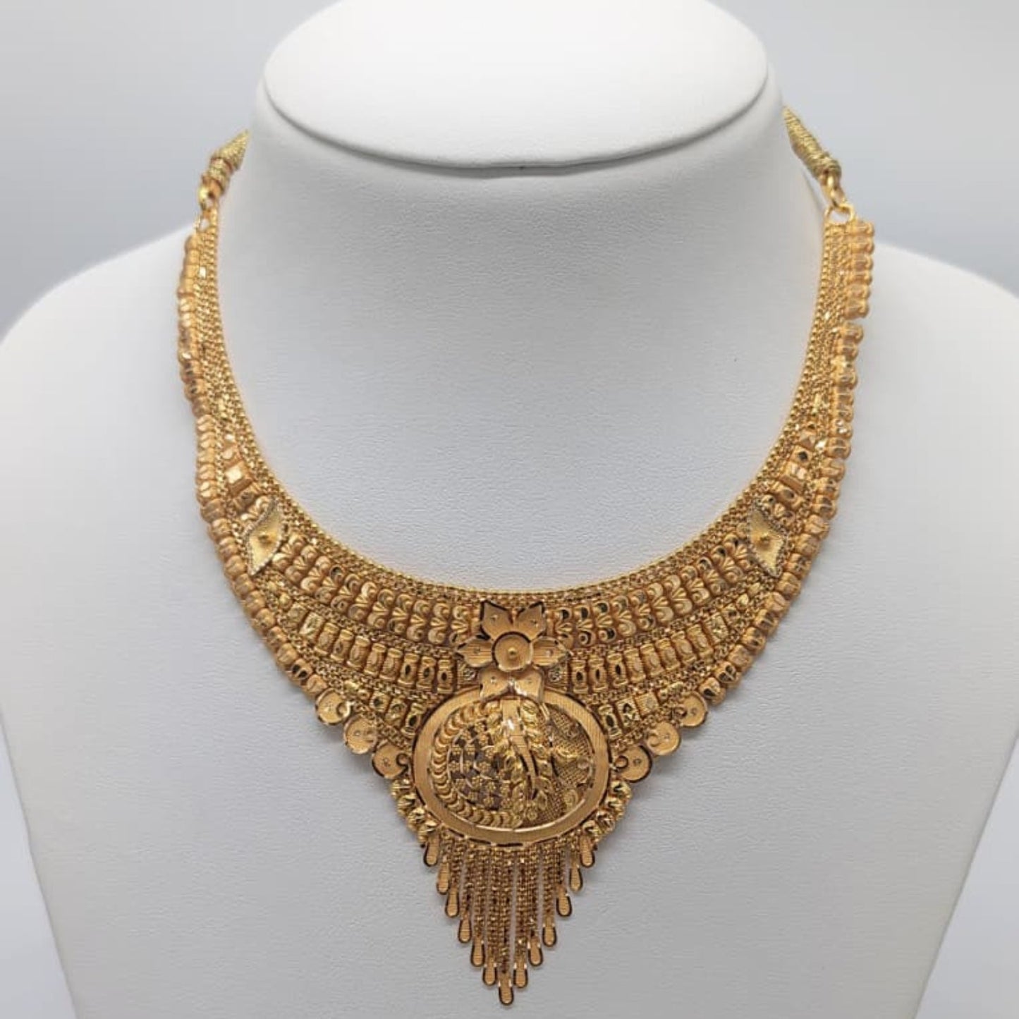 Gold necklace on a mannequin with weight displayed