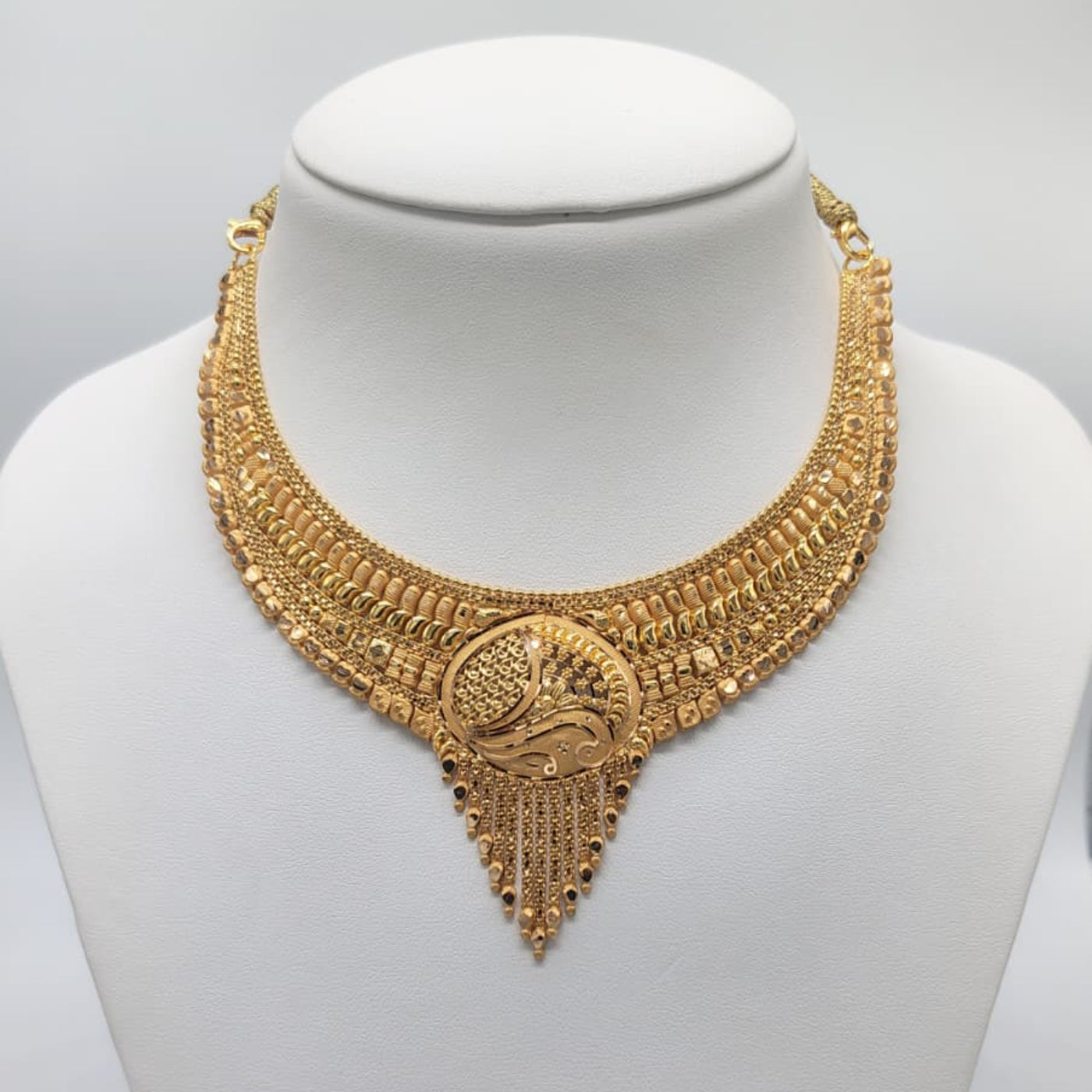 Gold necklace on a mannequin with weight displayed