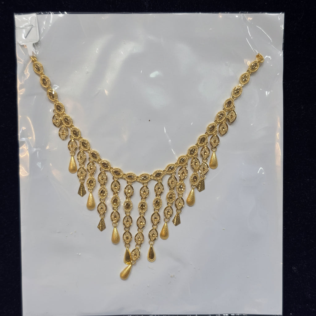 Gold necklace on a clear plastic sheet with a label