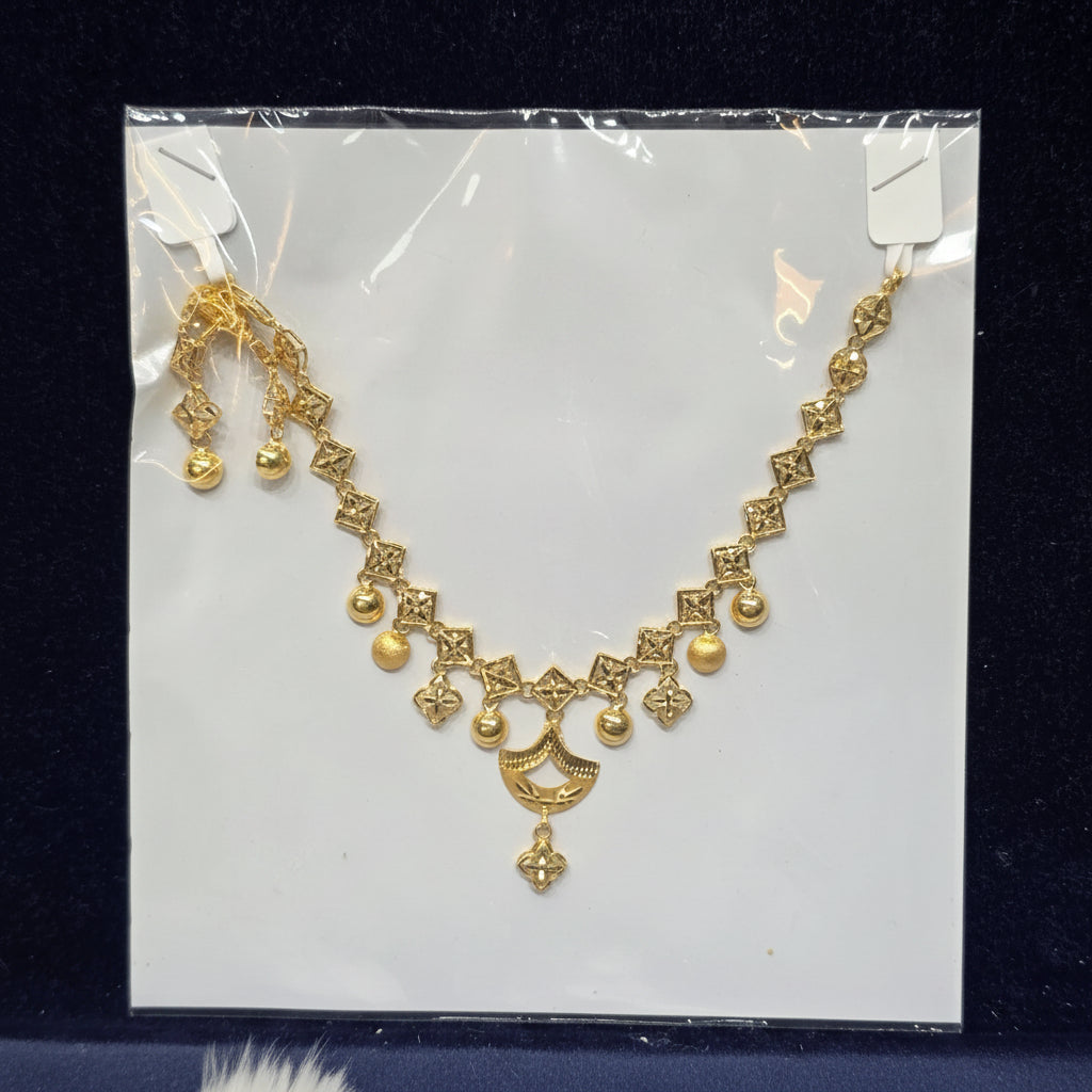 Gold necklace in clear packaging on a dark background