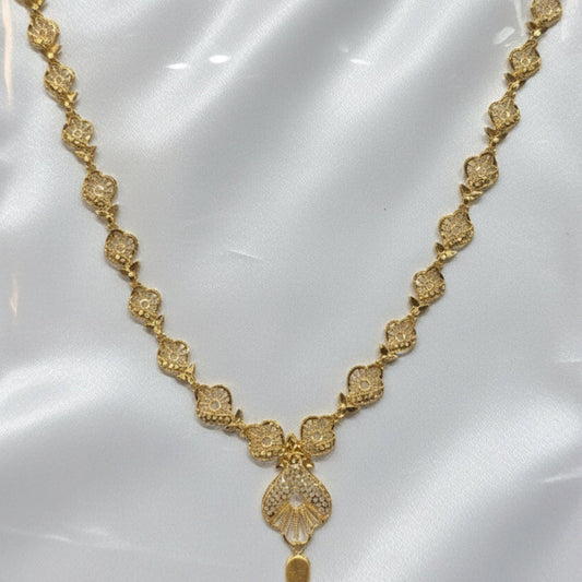 Gold necklace on a white card with a visible price tag.