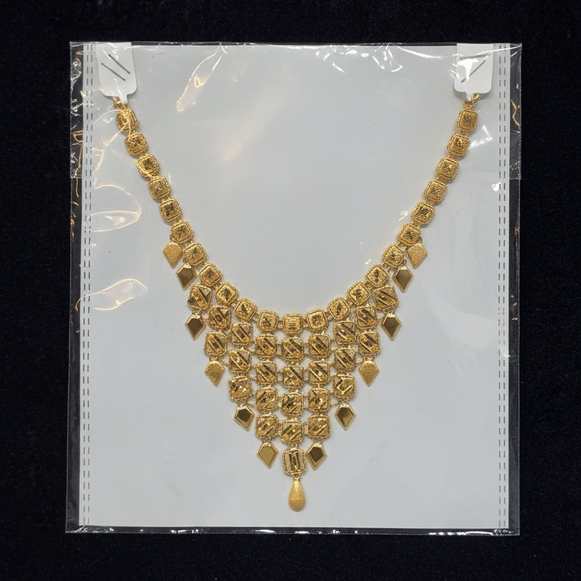 Gold necklace on a clear plastic bag with a black background