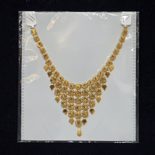 Gold necklace on a clear plastic bag with a black background