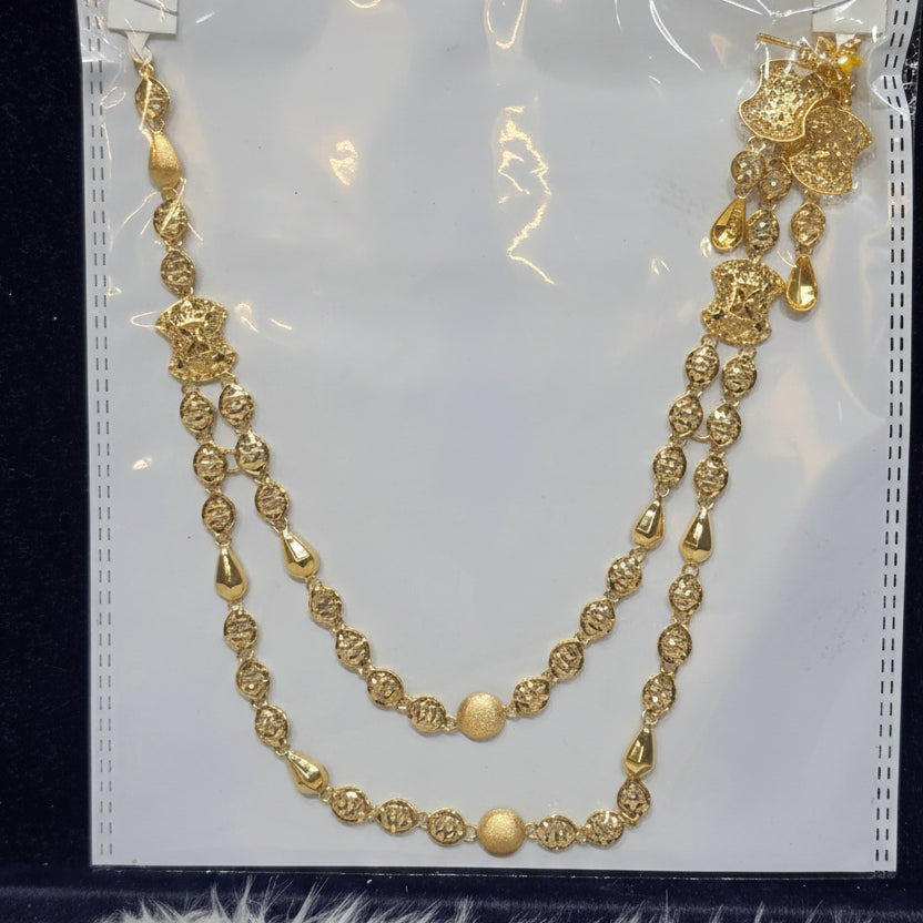 Gold necklace on a clear plastic sheet with a label