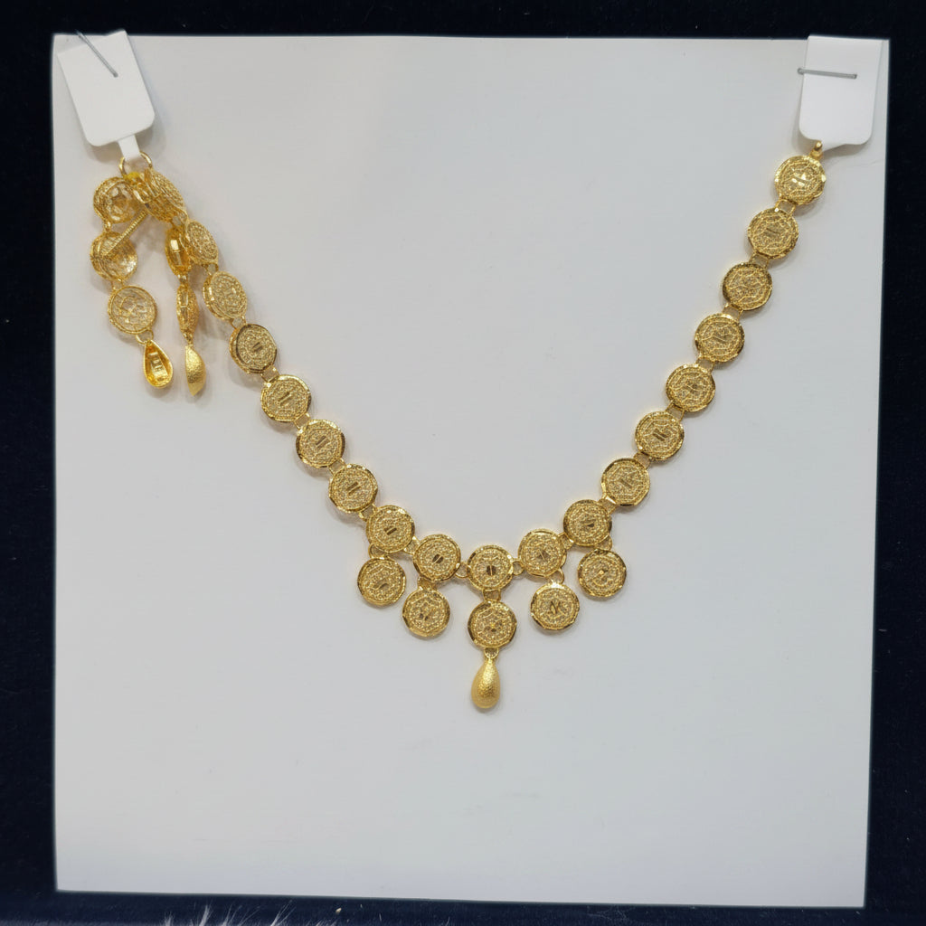 Gold necklace on a white card with a black background