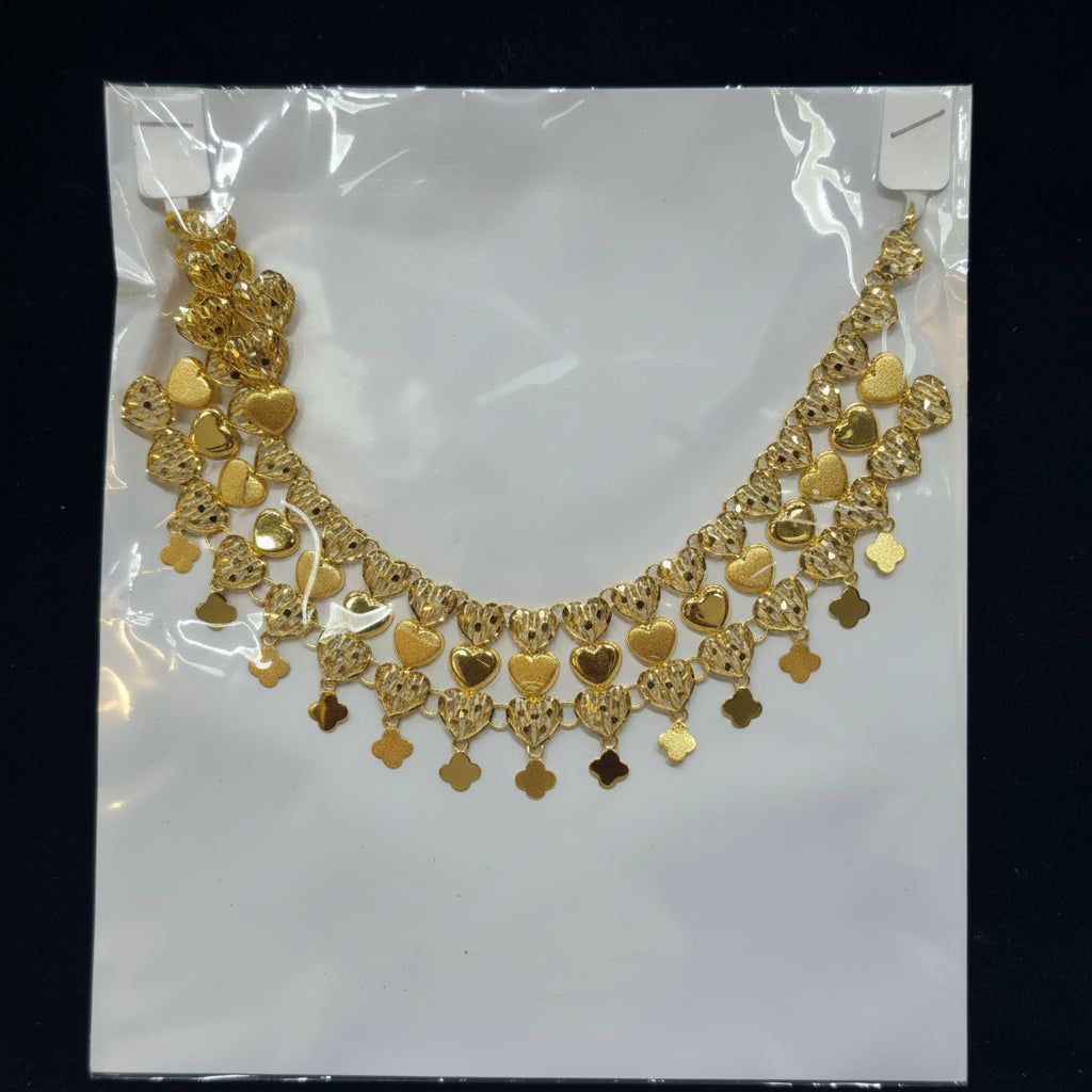 Gold necklace on a white card with a black background