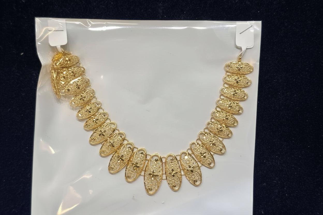 Gold necklace on a clear plastic bag with a black background