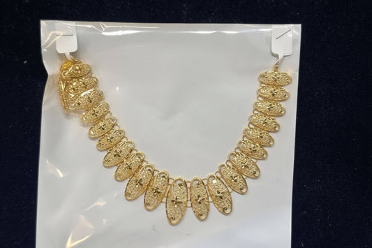 Gold necklace on a clear plastic bag with a black background