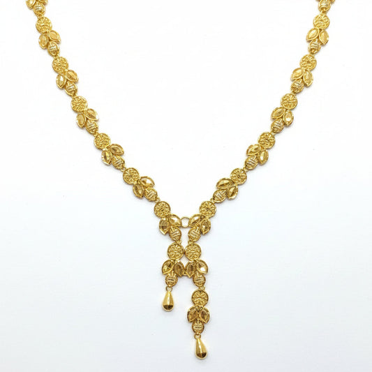 Gold necklace on a white card with a hand touching the top left corner.