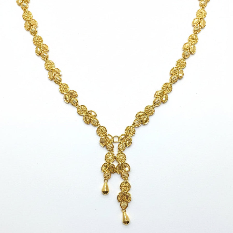Gold necklace on a white card with a hand touching the top left corner.