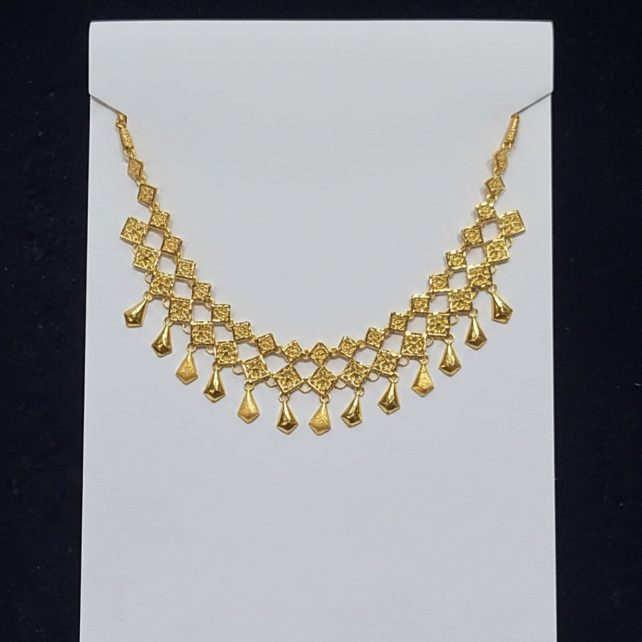 Gold necklace on a clear plastic bag with a black background