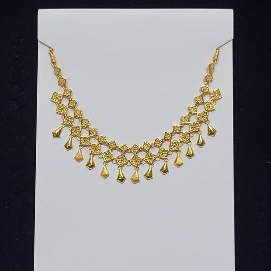 Gold necklace on a clear plastic bag with a black background